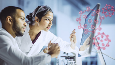 two people in lab coats looking at a computer